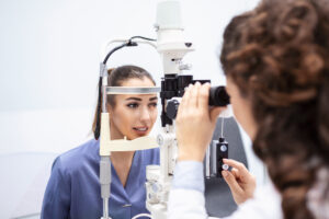 Female doctor ophthalmologist is checking the eye vision of attractive young woman in modern clinic. Doctor and patient in ophthalmology clinic